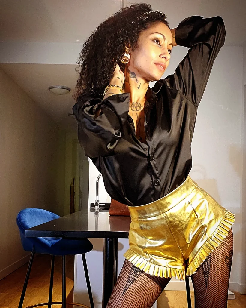 Stylish lady in a luxurious gold attire posing gracefully for a chic photograph.
